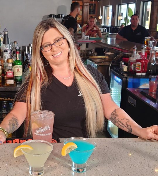 Martinis mixologist is show making martinis for visitors to the top restaurant with ooutdoor seating.